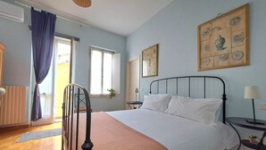 A bedroom with a bed, a chair, a bedside table, a lamp, a window, and a door. - Aristocratic Residence  (Verona)