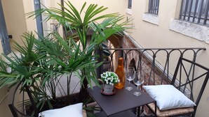 A small outdoor table with a bottle, two glasses, and a flower arrangement on a balcony. - Aristocratic Residence  (Verona)