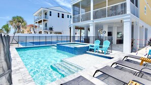 A pool area with a hot tub, lounge chairs, and a two-story building with balconies. - ☀️Private Pool and Pickleball Court | Short Walk to Beach | Dink or Swim☀️ (Fort Myers Beach)