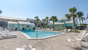 Un espace piscine avec des chaises longues et une piscine.