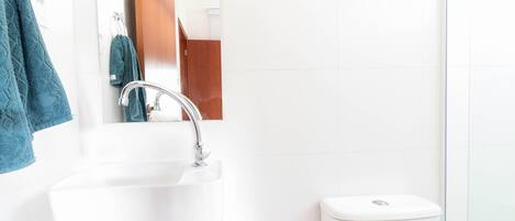 Een badkamer met een witte wastafel, een spiegel en een toilet.