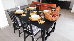 A dining table set with plates, cutlery, glasses, and a basket of fruit. - APARTMENT AND TERRACE 100 SQM SEA VIEW+PANORAMA LEMEGLIO PRIVATE PARKING (Moneglia)