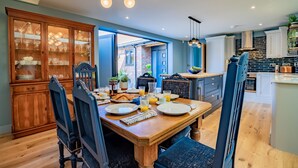 Comedor con una mesa de madera lista para el desayuno, rodeado de sillas.