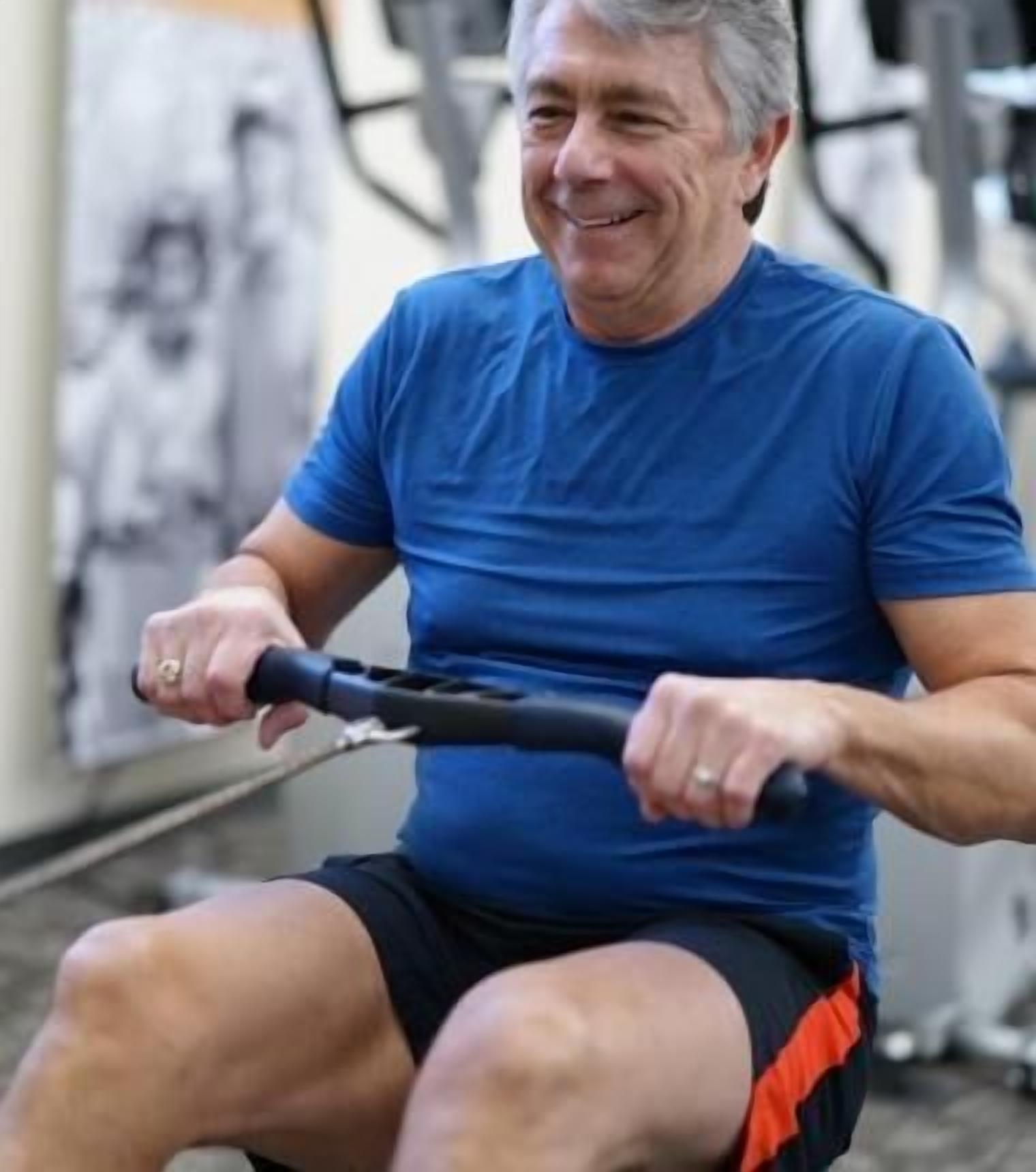 A person using a rowing machine in a gym setting.