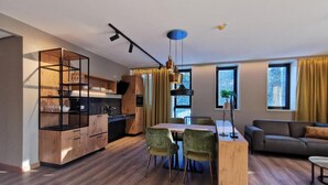 A modern living space with a kitchen, dining area, and seating area. - Appartementen De Egmonden (Egmond aan Zee)