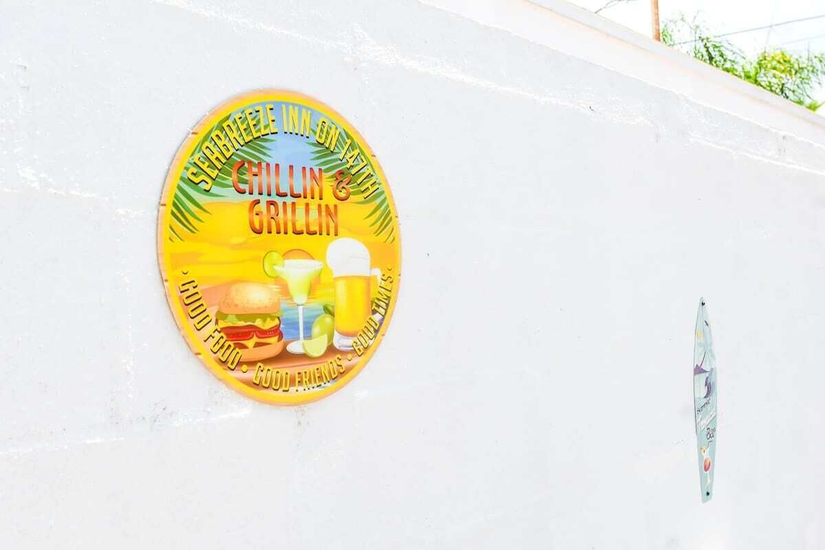 A circular sign with the text "Sea Breeze Inn & Grillin" and images of food and drinks.
