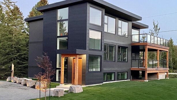 A modern two-story house with large windows, a balcony, and a well-maintained lawn. - 107 Birchview Trail (The Blue Mountains)
