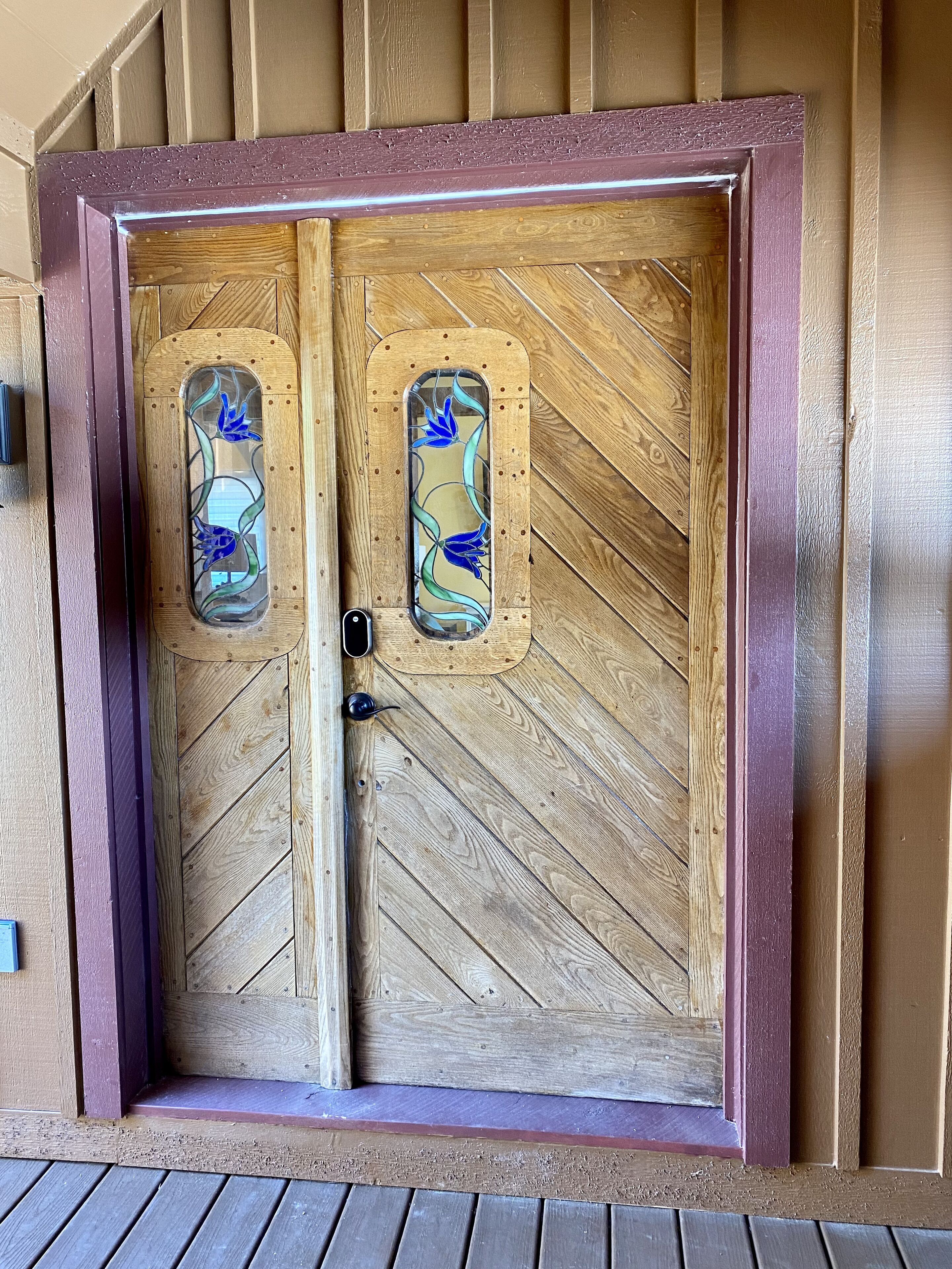 A wooden double door with glass panels and a metal handle.