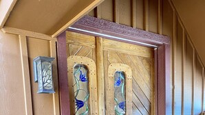 A wooden door with glass panels and a metal handle. - Ellie’s Loft in the heart of downtown Nashville, IN. (Nashville)