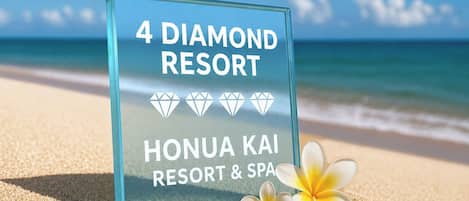 A sign for 4 Diamond Resort on a beach with a clear sky.