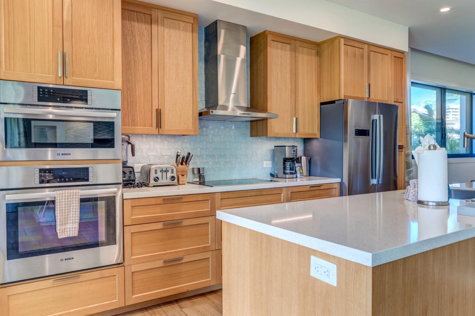 A modern kitchen with wooden cabinets, stainless steel appliances, and a large island.