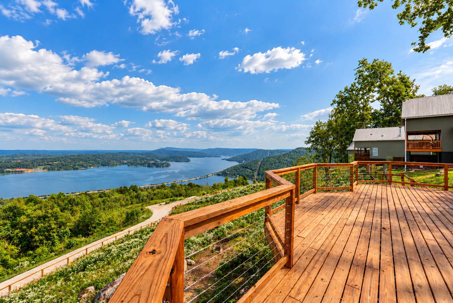 Une terrasse en bois offrant une vue sur un lac et des collines.