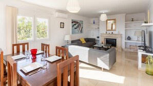 A modern living room with a dining area, a fireplace, and a TV. - Villa Diego - Five Bedroom Villa, Sleeps 10 (Puerto del Carmen)
