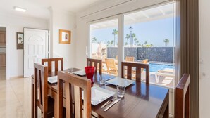 A dining area with a view of a pool and palm trees. - Villa Diego - Five Bedroom Villa, Sleeps 10 (Puerto del Carmen)