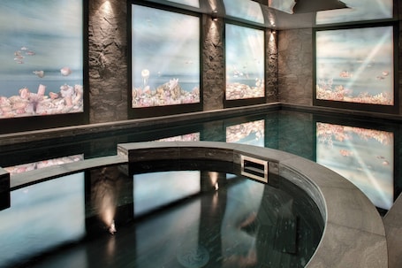 Una piscina techada, sillones reclinables de piscina