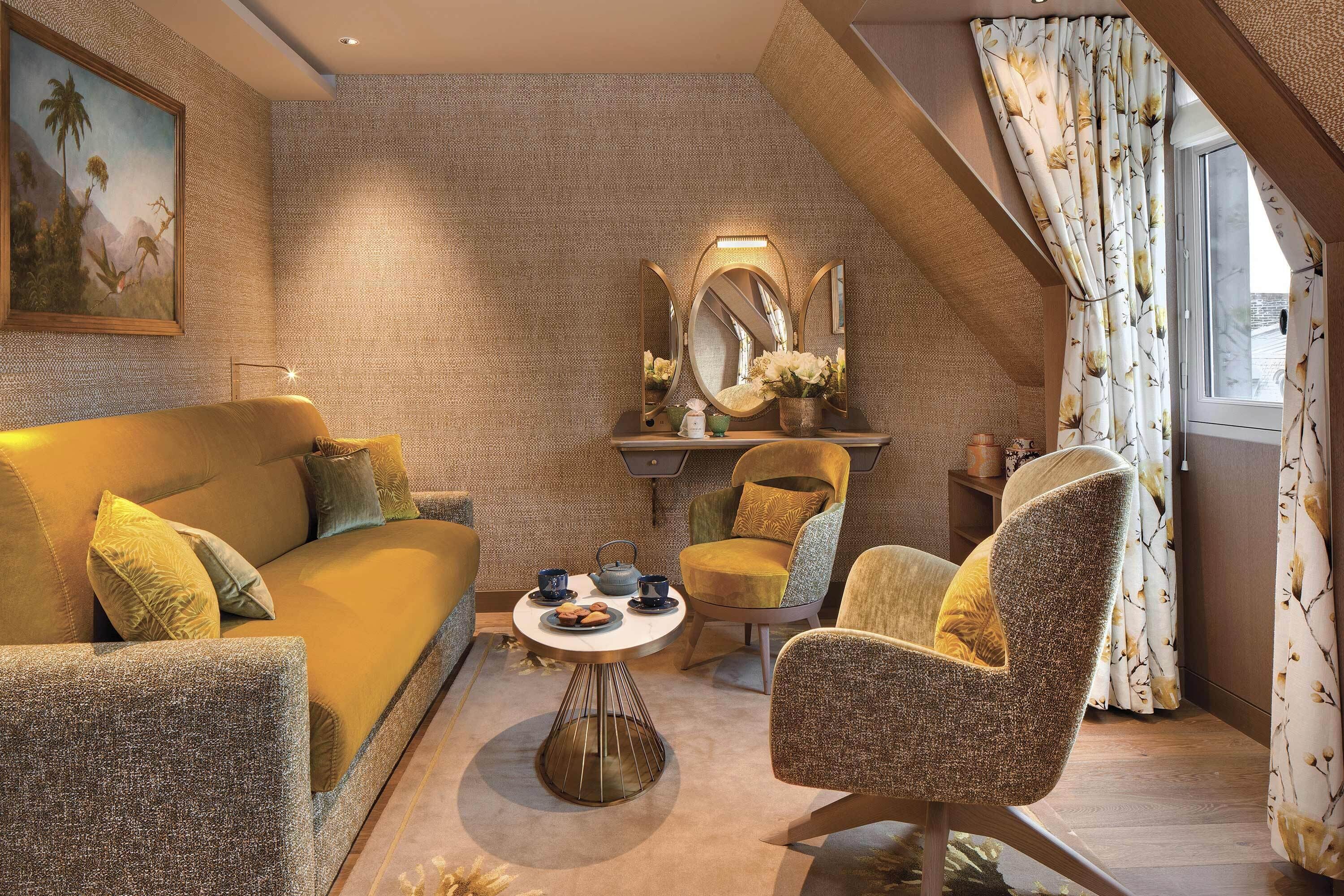 A cozy living room with a sofa, armchairs, a coffee table, and a decorative mirror.