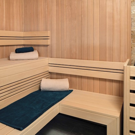 A sauna with wooden benches and a stone wall.