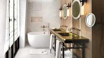 A modern bathroom with a freestanding bathtub, a vanity with a gold sink, and two wall-mounted mirrors.