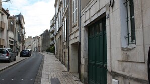 A narrow street lined with historic buildings, featuring a green door on the right. - Appartement champêtre - Déconnexion assurée (Poitiers)