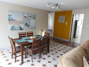 Ein Essbereich mit Holztisch und -stühlen, einer Deckenleuchte und Bildern an den W änden.
