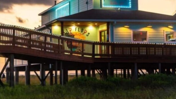 Un edificio frente al agua con un letrero que dice 'The Flop Joint'.
