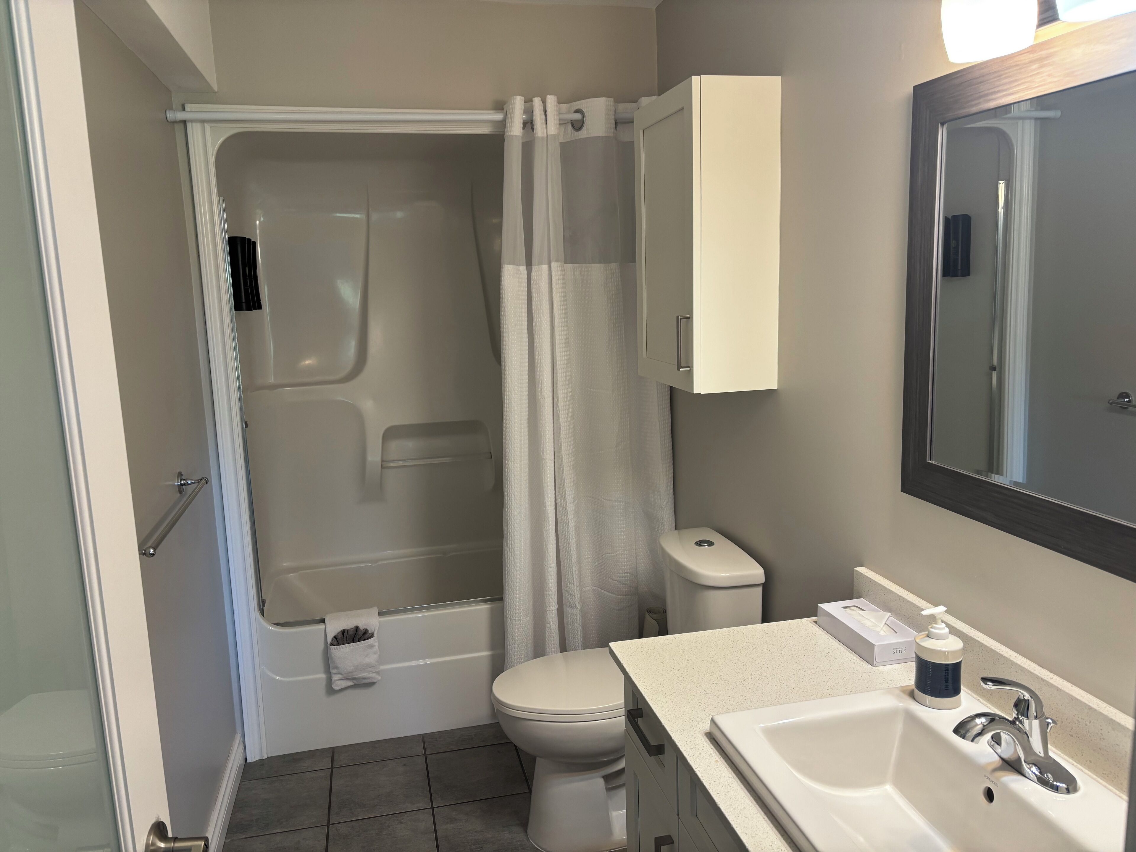 Un baño con bañera, inodoro, lavabo y espejo.