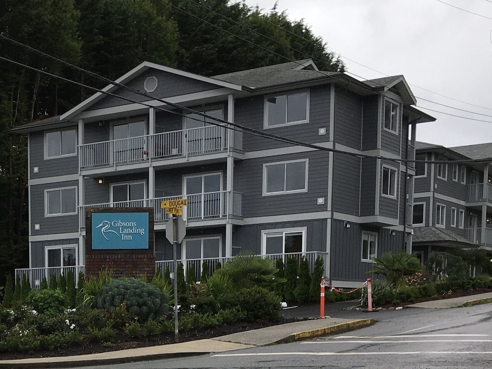 A multi-story hotel with balconies, a sign for 'Gibsons Landing Inn', and a 'DOUGALL' street sign.