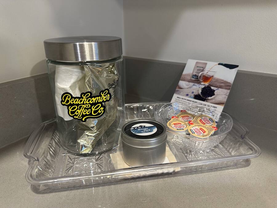 A tray with a Beachcomber Coffee Co. branded container, a small tin of tea, and several packets of tea.