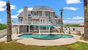 A two-story house with a swimming pool, a covered deck, and a staircase leading to a balcony. - Luxury Beach Estate Ocean view, Pool, 360° Deck&Beach Access 20%off last minute  (Surfside Beach)