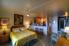 A bedroom with a bed, nightstand, lamp, and a ceiling fan. - Oceanview Condo in Hana-Let the ocean lull you to sleep (Hana)
