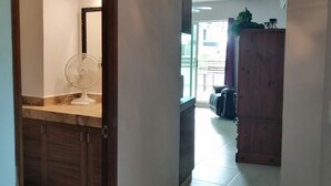A hallway with a tiled floor, a wooden cabinet, and a mirror. - 1bedroom apartment, quiet and relaxing atmosphere.  (Bucerias)
