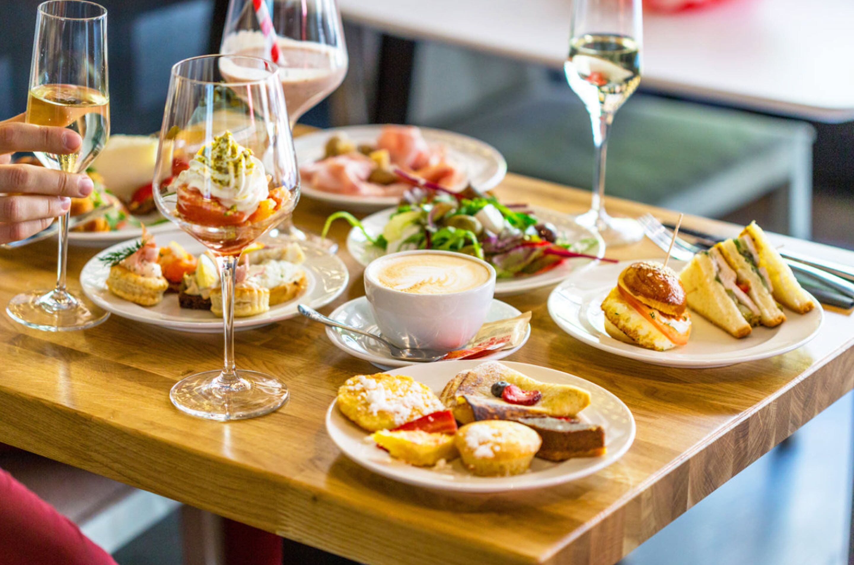 Una mesa servida con diversos platos, copas de vino y una taza de café.
