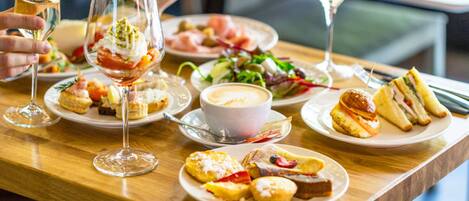 Una mesa servida con diversos platos, copas de vino y una taza de café.
