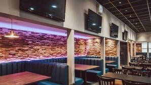 A restaurant with booths and tables, a brick wall, and ceiling lights. - Lovely 3-bed Caravan in Towyn (Abergele)