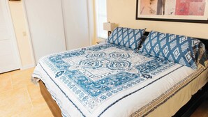 A bedroom with a bed, a nightstand, a lamp, a wardrobe, and a framed picture on the wall. - Home Sweet Desert Sum (Green Valley)