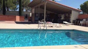 A swimming pool with lounge chairs and a covered area. - Home Sweet Desert Sum (Green Valley)