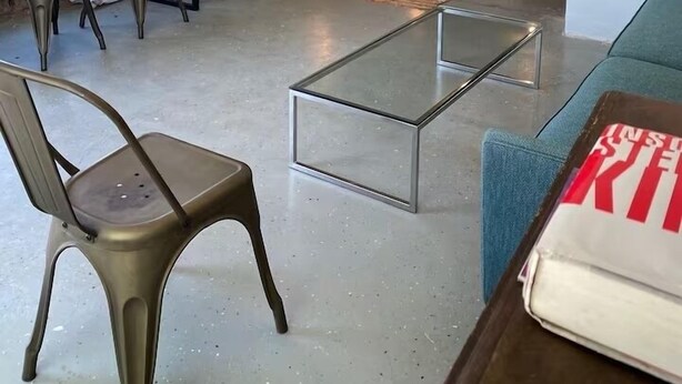 A modern hotel room with a bed, a desk, and a seating area.