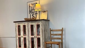 Ein Zimmer mit einem rustikalen Holzschrank, einem Holzstuhl und einer an der Wand befestigten Klimaanlage.