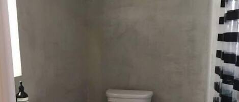 A small, narrow bathroom with a white sink and toilet.