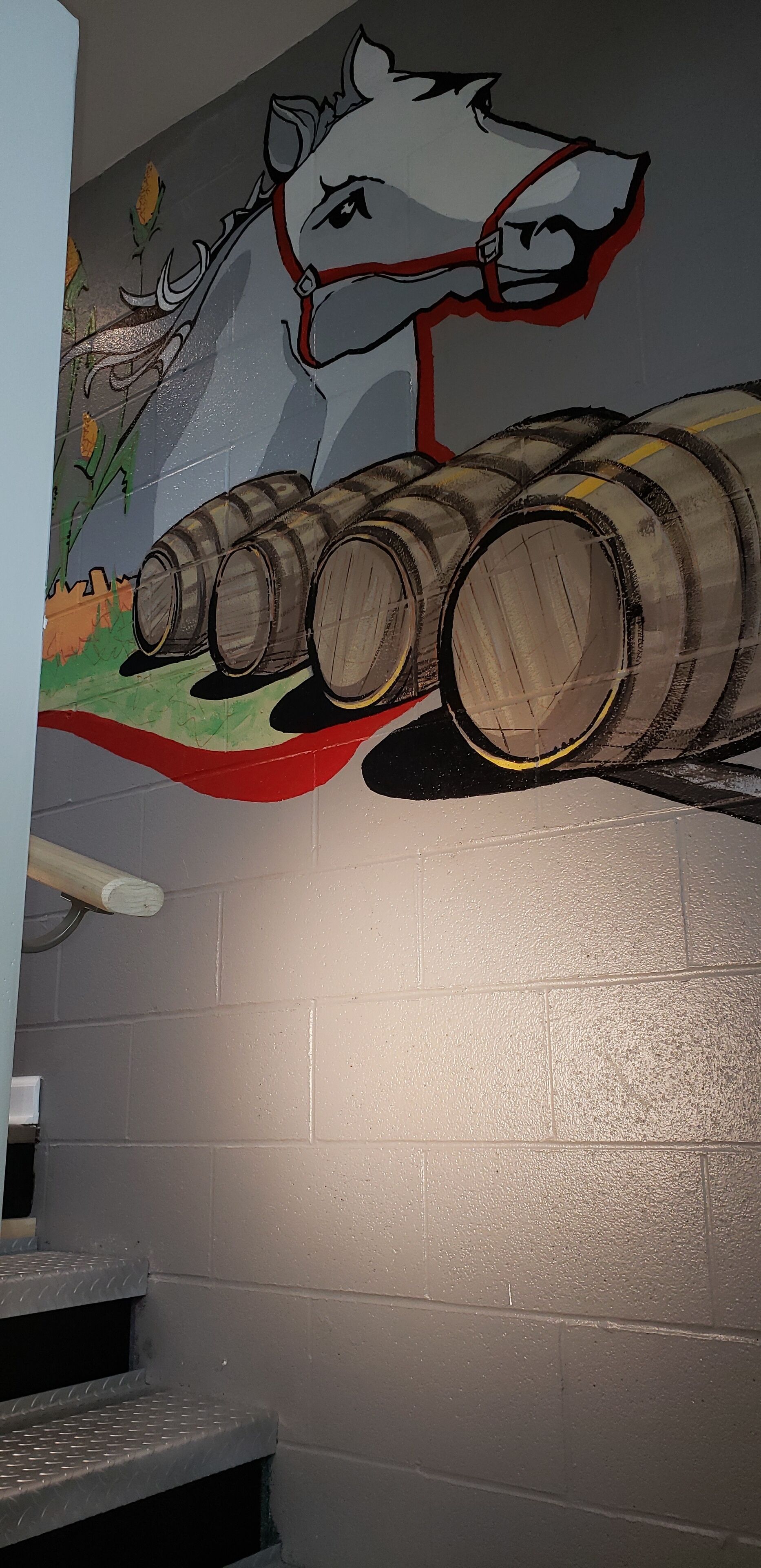 A mural of a horse and barrels on a wall.