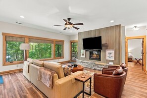 A modern living room with a sofa, a fireplace, and a television.