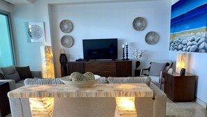 A modern living room with a large flat-screen TV, decorative wall art, and a unique light-up table centerpiece.