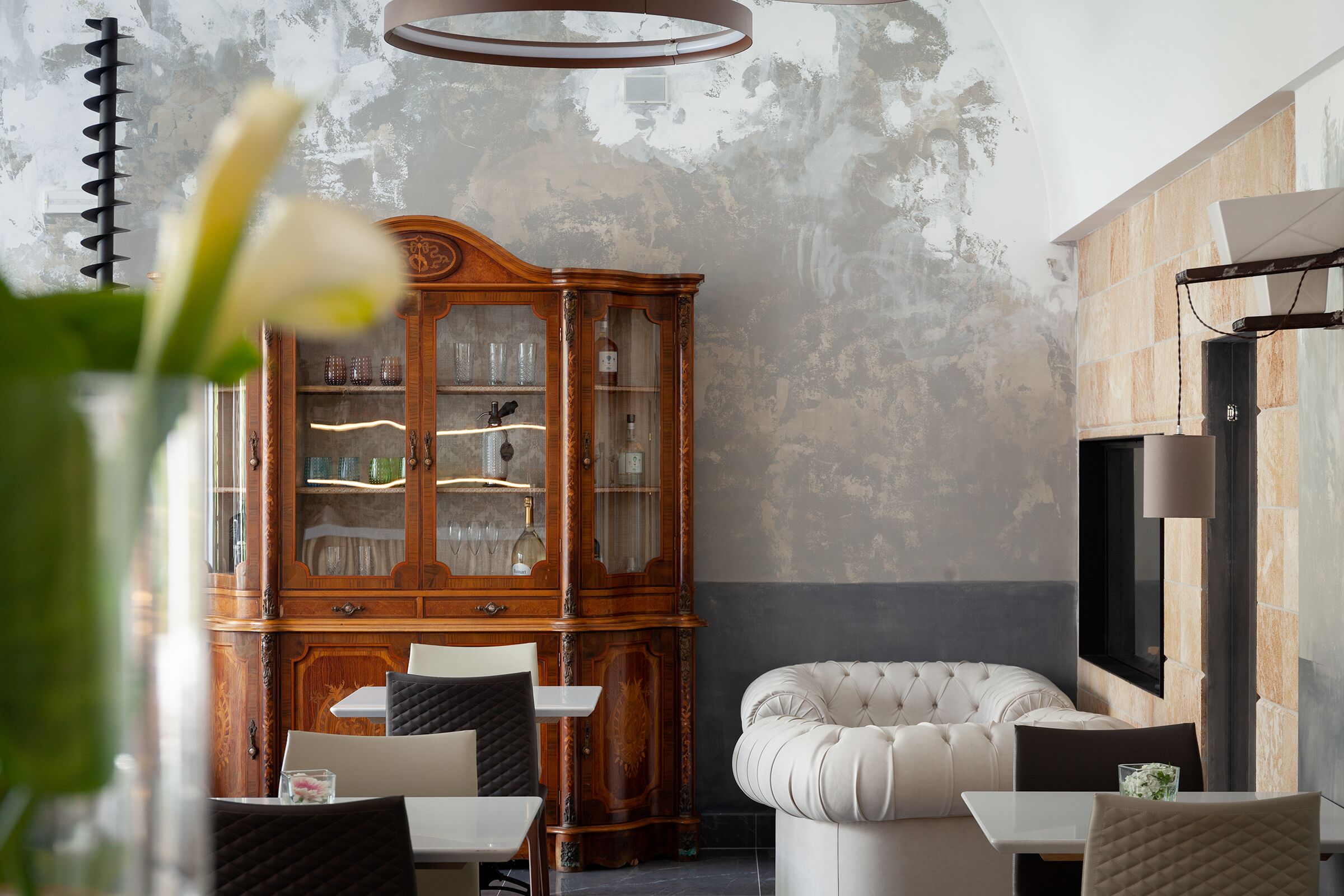 Un interior moderno con un armario de madera, un sofá capitonado y una zona de comedor.