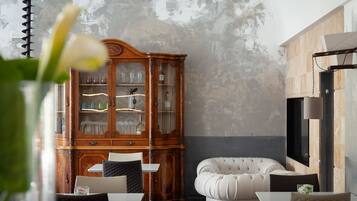 Un interior moderno con un armario de madera, un sofá capitonado y una zona de comedor.