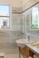 Habitación junior con 1 cama doble o 2 individuales | Baño | Ducha, cabezal de ducha tipo lluvia, secador de pelo y zapatillas