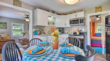 Un coin repas avec une nappe à carreaux, des chaises et un vase rempli de fleurs.