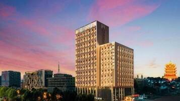 A high-rise building with a modern architectural design, surrounded by other buildings and a cityscape.