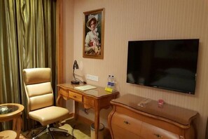 A hotel room with a desk, chair, television, and a painting on the wall. - Vienna International Hotel (Wuhan Yellow Crane Tower Pengliuyang Subway Station) (Wuhan)