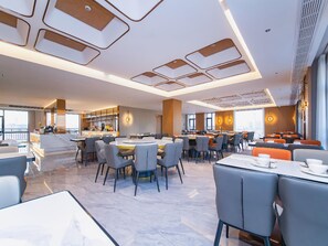 A modern hotel lobby with a central seating area, a bar, and a view of the city. - Vienna International Hotel (Wuhan Yellow Crane Tower Pengliuyang Subway Station) (Wuhan)