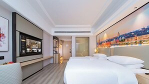 A hotel room with a bed, bedside table, a desk with a chair, a large window, and a wall-mounted TV. - Vienna International Hotel (Wuhan Yellow Crane Tower Pengliuyang Subway Station) (Wuhan)